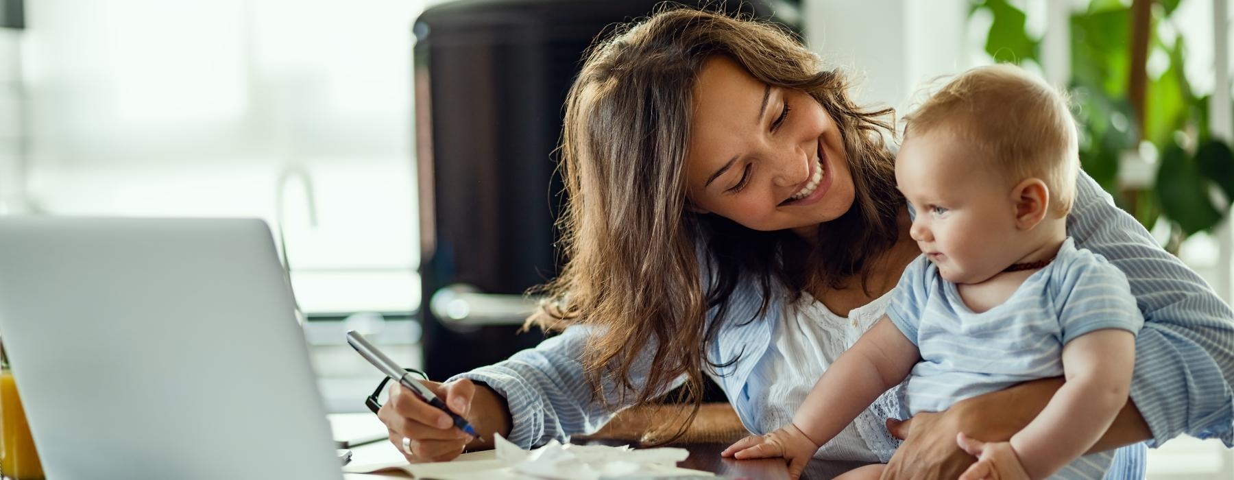 a person and a baby looking at a laptop