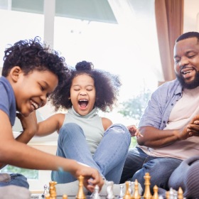 A family playing together in SkyMor Research Park Living Room | New 3&4 Bed Townhomes for Rent in Charlotte, NC